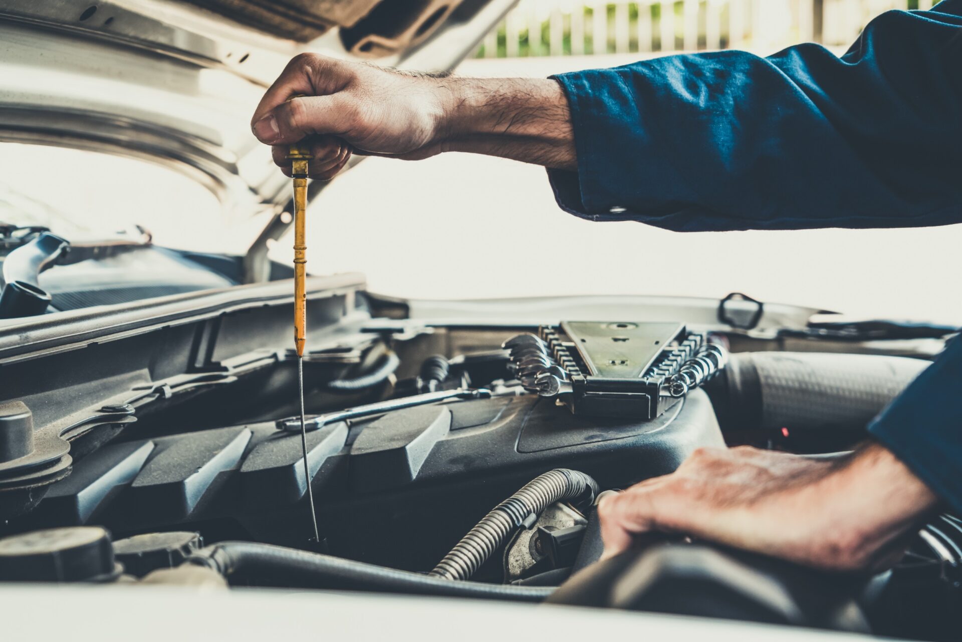 Professional mechanic holding screw driver for repair and maintenance service in auto garage